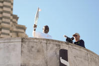 French torchbearer Basile Boli participates in the first stage of the Olympic torch relay in Marseille, southern France, Thursday, May 9, 2024. Torchbearers are to carry the Olympic flame through the streets of France' s southern port city of Marseille, one day after it arrived on a majestic three-mast ship for the welcoming ceremony. (AP Photo/Thibault Camus)