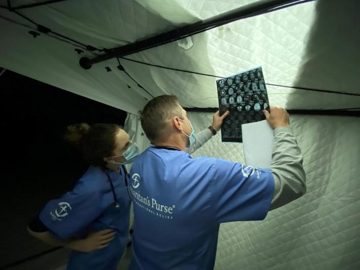 Chris Brandenburg (right) examines an X-ray with another Samaritan's Purse physician.
