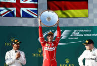 Formula One - F1 - Australian Grand Prix - Melbourne, Australia - 26/03/2017 - Ferrari driver Sebastian Vettel of Germany (C) celebrates alongside Mercedes driver Lewis Hamilton of Britain (L) and team mate Valtteri Bottas of Finland. REUTERS/Brandon Malone