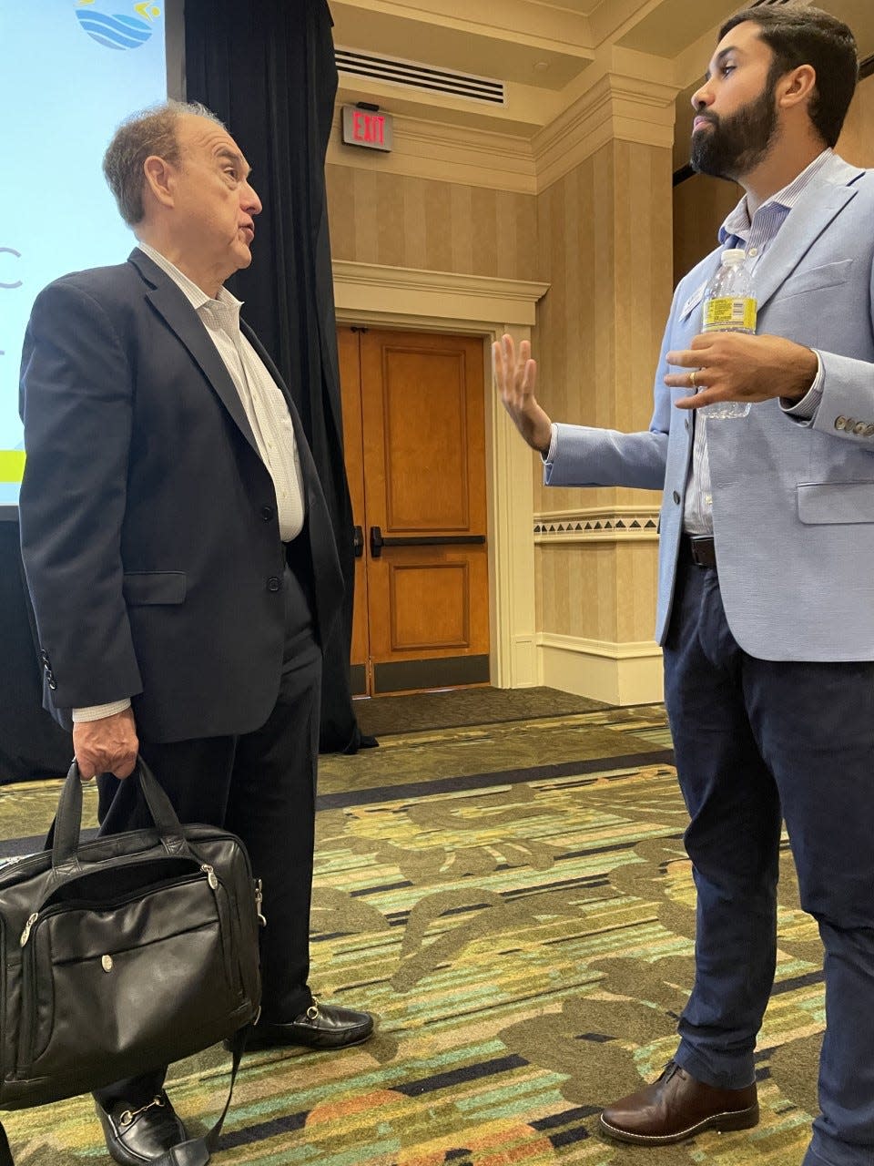Amir Ferreira Neto (right), director of Florida Gulf Coast University's Regional Economic Research Institute, talks one-on-one after a presentation on the local economy at the Hilton Naples on Aug. 3, 2022.  The event was sponsored by the Greater Naples Chamber of Commerce.