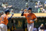 Houston Astros' Kyle Tucker (30) is congratulated by Yuli Gurriel (10) after hitting a solo home run during the eighth inning of a baseball game in Oakland, Calif., Sunday, July 10, 2022. (AP Photo/John Hefti)