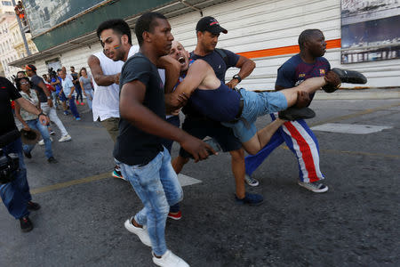 A Cuban LGBT activist is detained by plain-clothed security personnel while participating in an annual demonstration against homophobia and transphobia in Havana, Cuba May 11, 2019. REUTERS/Stringer