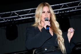 Kim Zolciak in a black suit talking into a microphone