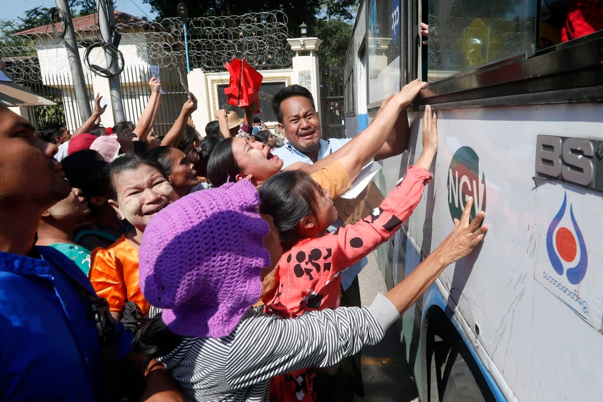 Relatives react as a bus carrying released inmates exits Insein prison in Yangon, Myanmar (EPA)