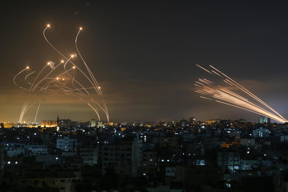 Israel's Iron Dome missile defense system (left) intercepts rockets (right) fired by Hamas towards southern Israel from the northern Gaza Strip, as seen in the sky above Gaza overnight on May 14, 2021. / Credit: ANAS BABA/AFP via Getty Images