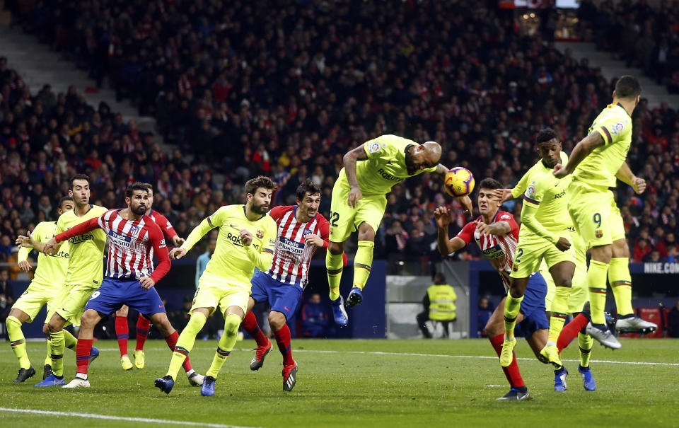 Barcelona's Arturo Vidal center jumps for the ball leaving his arm in the way during a Spanish La Liga soccer match between Atletico Madrid and FC Barcelona at the Metropolitano stadium in Madrid, Saturday, Nov. 24, 2018. (AP Photo/Paul White)