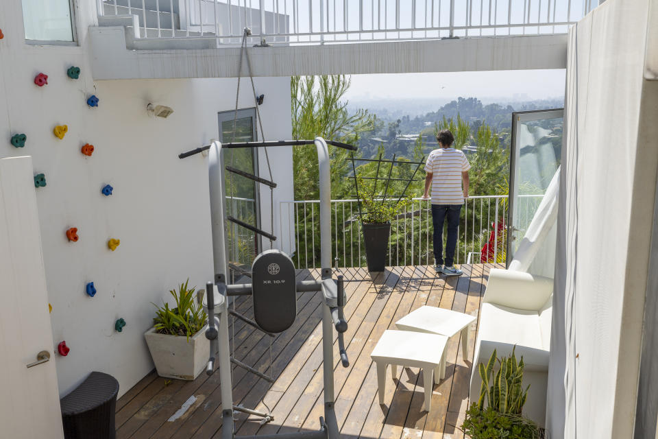 Aleksandar Jovanovic mira hacia la ciudad de Los Angeles desde la terraza de su casa. La casa se huéspedes que habita Elizabeth Hirschhorn sin pagar alquiler se observa a la izquierda de la imagen.  (Allen J. Schaben/Los Angeles Times vía Getty Images)