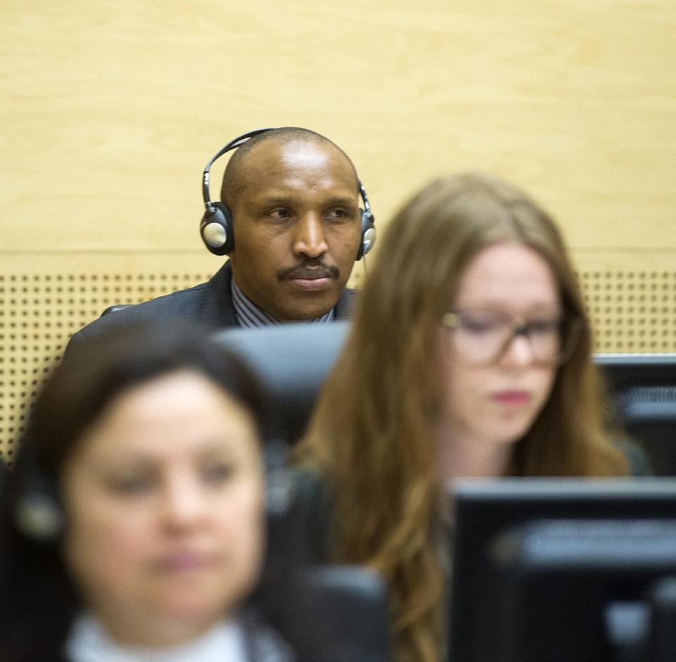 Bosco Ntaganda, center rear, awaits the start of a hearing at the International Criminal Court (ICC) in The Hague, Netherlands, Monday Feb. 10, 2014. Judges at the ICC are weighing whether there is enough evidence to proceed to trial in the case against Bosco Ntaganda, the former leader of a rebel group in Congo’s unstable eastern region. Prosecutor Fatou Bensouda accused Ntaganda of 13 charges of war crimes and 5 charges of crimes against humanity for acts including murder, rape, persecution and recruiting child soldiers. Ntaganda's lawyers have said he is innocent of any wrongdoing. (AP Photo/Toussaint Kluiters, Pool)