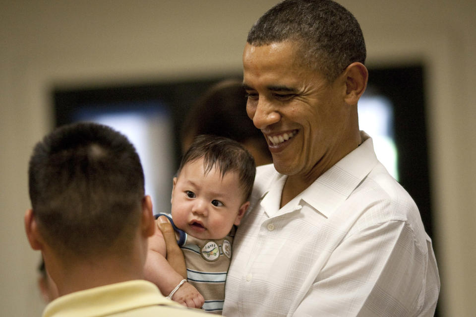 President Barack Obama holds a baby as he greets members of the US Military and their families at Anderson Hall at Marine Corps Base Hawaii on December 25, 2010 in Kaneohe, Hawaii. (Kent Nishimura/Getty Images)