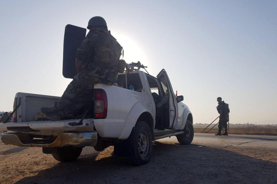 In this photo released by the Syrian official news agency SANA, Syrian troops deploy in the northern town of Tal Tamr, Monday, Oct 14, 2019. The move toward Tal Tamr came a day after Syria's Kurds said Syrian government forces agreed to help them fend off Turkey's invasion — a major shift in alliances that came after President Donald Trump ordered all U.S. troops withdrawn from the northern border area amid the rapidly deepening chaos. (SANA via AP)