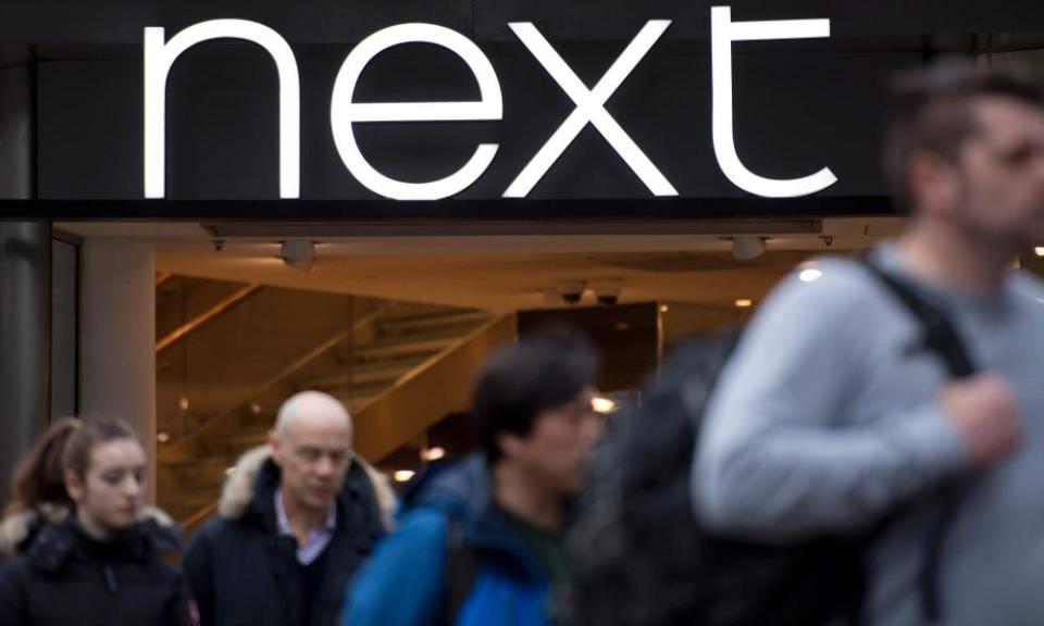 People walk past a branch of Next retail store on Oxford Street