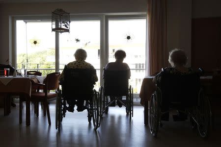 Pensioners sitting in wheelchairs are silhouetted at a residential home for the elderly in Eichenau near Munich in this June 21, 2011 file photo. REUTERS/Michaela Rehle/Files