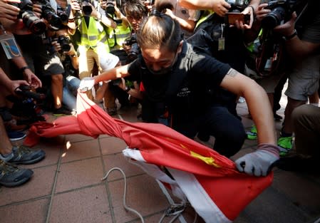 An anti-government protester destroys a Chinese flag during a protest in Tuen Mun, Hong Kong