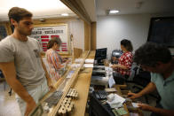 People change money at a currency exchange shop in Istanbul, Wednesday, Aug. 15, 2018. The Turkish lira currency has nosedived in value in the past week over concerns about Turkey's President Recep Tayyip Erdogan's economic policies and after the United States slapped sanctions on Turkey angered by the continued detention of an American pastor. (AP Photo/Lefteris Pitarakis)