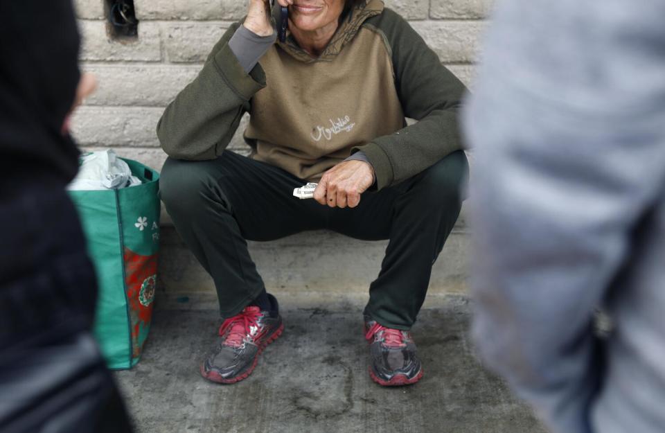A woman talks to her mother on the phone outside of a 7-Eleven.
