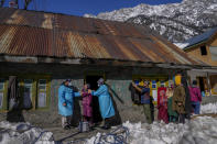 Kashmiri village girl Tanveera Banoo, reacts as she receives a vaccine for COVID-19 from Masrat Farid, a healthcare worker, as her neighbors watch from distance during a COVID-19 vaccination drive in Gagangeer, northeast of Srinagar, Indian controlled Kashmir, Jan. 12, 2022. (AP Photo/Dar Yasin)