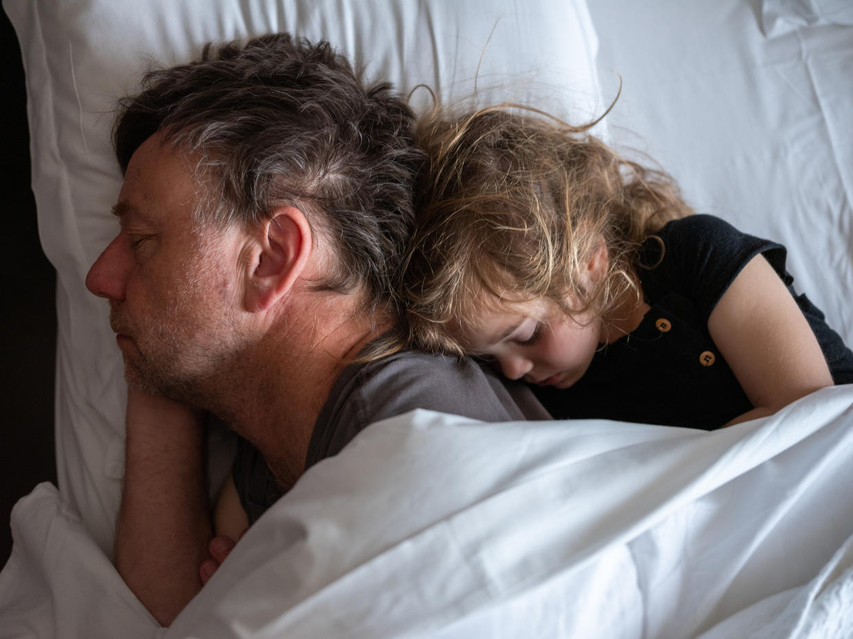 Father and daughter cuddling in bed