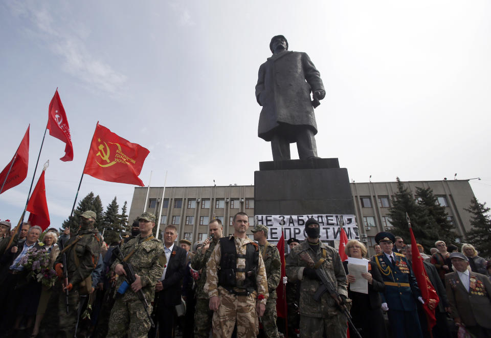 Pro-Russian gunmen stand guard in front of the monument of Soviet Union founder Vladimir Lenin, during a Victory Day celebration, which commemorates the 1945 defeat of Nazi Germany, in the center of Slovyansk, eastern Ukraine, Friday, May 9, 2014. Putin's surprise call on Wednesday for delaying the referendum in eastern Ukraine appeared to reflect Russia's desire to distance itself from the separatists as it bargains with the West over a settlement to the Ukrainian crisis. But insurgents in the Russian-speaking east defied Putin's call and said they would go ahead with the referendum. (AP Photo/Darko Vojinovic)