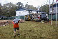 In this photo provided by Gabriella Rico, volunteers from Home Depot work to build a garden and water feature on the campus of the Veterans Empowerment Organization in Atlanta, Nov. 10, 2023. Company employees have volunteered more than 1.5 million hours in service to veterans, including building or repairing 60,000 houses and facilities for former service members. (Gabriella Rico via AP)