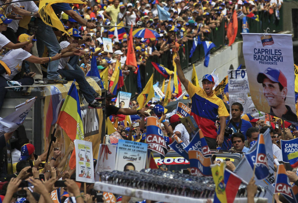 ALTERNATIVE CROP OF XFLL104 - Opposition presidential candidate Henrique Capriles, center, gestures to supporters during a campaign rally in Caracas, Venezuela, Sunday, Sept. 30, 2012. Presidential elections in Venezuela are scheduled for Oct. 7. (AP Photo/Fernando LLano)