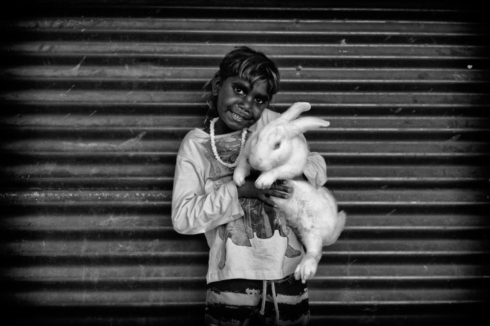 What a wonderful surprise to see this perfect white rabbit being cared for by Romaine. Romaine and his family came over from the Wangkatjungka Community about 700 km’s from Broome.  'We came to do some shopping’. One Mile Community, Broome, Western Australia. (Photograph by Ingetje Tadros/Diimex)