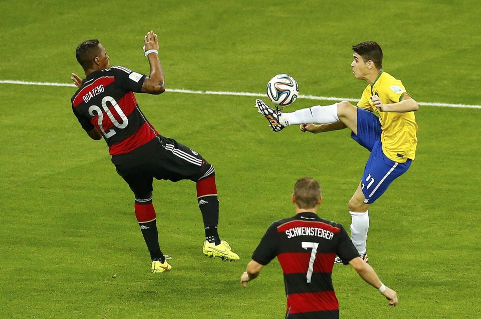 Brazil's Oscar (R) is challenged by Germany's Jerome Boateng (L) and Bastian Schweinsteiger during their 2014 World Cup semi-finals at the Mineirao stadium in Belo Horizonte July 8, 2014. REUTERS/Leonhard Foeger