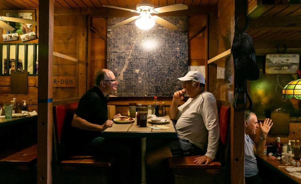 Michael Spivack, a la izquierda, y Gary Winston conversan mientras visitan el restaurante Wagons West el viernes 1º de julio de 2022, en Pinecrest, Florida.