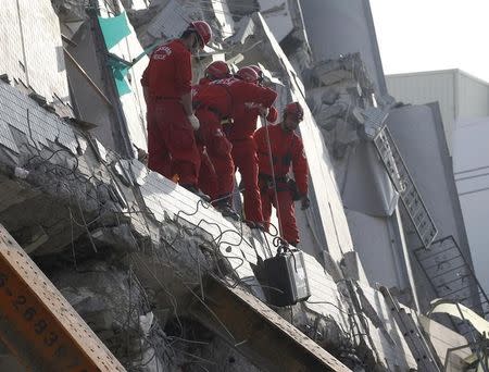 Rescue personnel work at the site where a 17 story apartment building collapsed from an earthquake in Tainan, southern Taiwan, February 7, 2016. REUTERS/Pichi Chuang