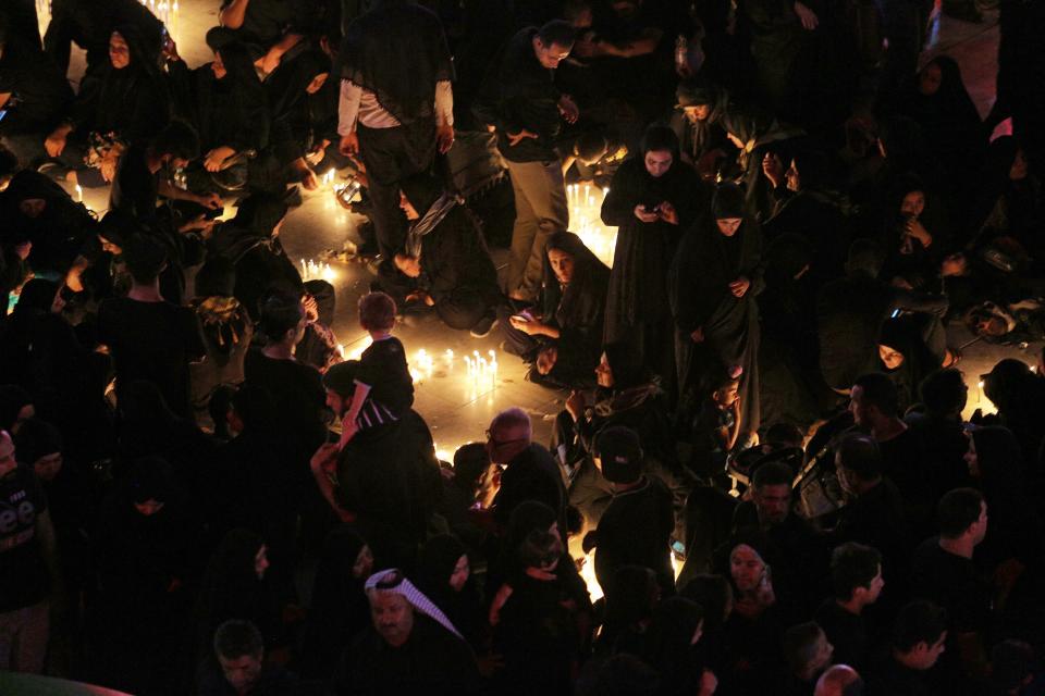 People pray for victims after a walkway collapsed and set off a stampede as thousands of Shiite Muslims marked one of the most solemn holy days of the year in the holy city of Karbala, Iraq, Tuesday, Sept. 10, 2019. Officials say at least 31 people have died and around 100 others were injured in the chaos Tuesday, which occurred toward the end of the Ashoura procession, causing panic and a stampede, according to two officials. (AP Photo/Anmar Khalil)