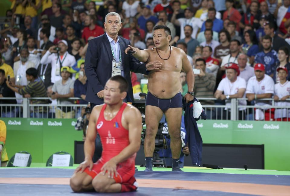 <p>The coach of Mandakhnaran Ganzorig (MGL) of Mongolia takes off his clothes as he protests after the match against Ikhtiyor Navruzov (UZB) of Uzbekistan. (Reuters) </p>