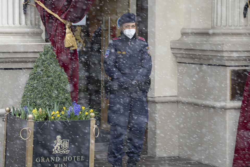 Snow falls as a police officer stands in front of the Grand Hotel Wien where closed-door nuclear talks with Iran take place in Vienna, Austria, Tuesday, April 6, 2021. Foreign ministry officials from the countries still in the accord, the so-called Joint Comprehensive Plan of Action, are meeting in Vienna to push forward efforts to bring the United States back into the 2015 deal on Iran's nuclear program. (AP Photo/Florian Schroetter)