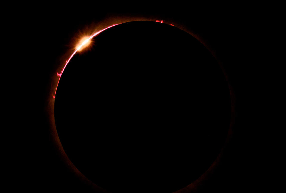 A solar eclipse showing the sun's corona and a bright prominence