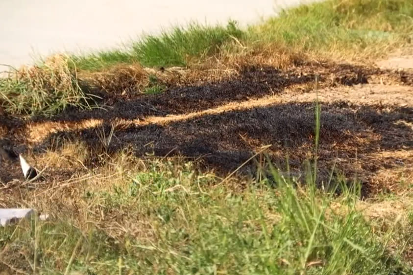 Image: Scarred ground where where three dismembered bodies, including a child, were found in a burning dumpster (not shown) on the city's west side on Wednesday. (KXAS)
