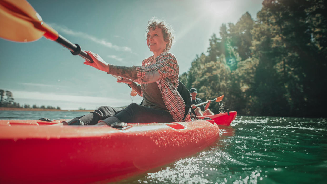 Shot of senior woman canoeing in lake on a summer day.