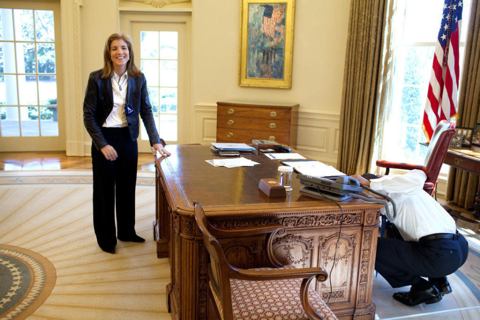 Obama examines the Resolute Desk on March 3, 2009, while visiting with Caroline Kennedy Schlossberg in the Oval Office. In a famous photograph, her brother John F. Kennedy Jr., peeked through the FDR panel, while his father worked.