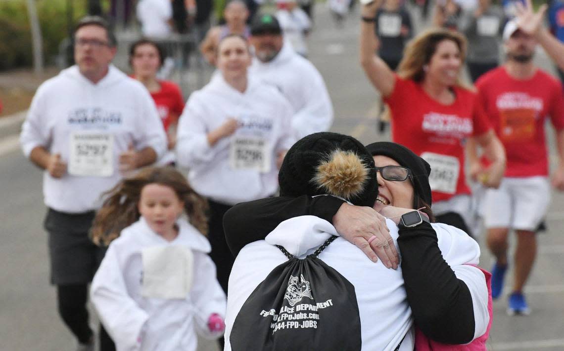 Terry Graham, left, is hugged by Leslie Beninga, right, after both finished the Gavin Galdding 5k Run/Walk together at the annual Two Cities Marathon on Sunday, Nov. 6, 2022, in Clovis.