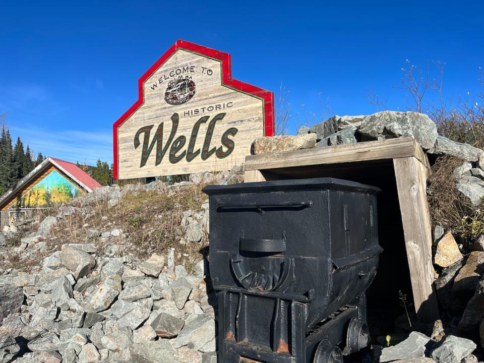 A wooden sign and mine shaft welcome visitors to the historic gold mining community of Wells, B.C.. 