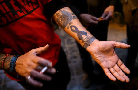 Paul Levely, a child sex abuse victim, wears a t-shirt that says "no more silence" and shows a tattoo on his arm as he stands in front of the Quirinale hotel in Rome, Italy, February 28, 2016. REUTERS/Alessandro Bianchi