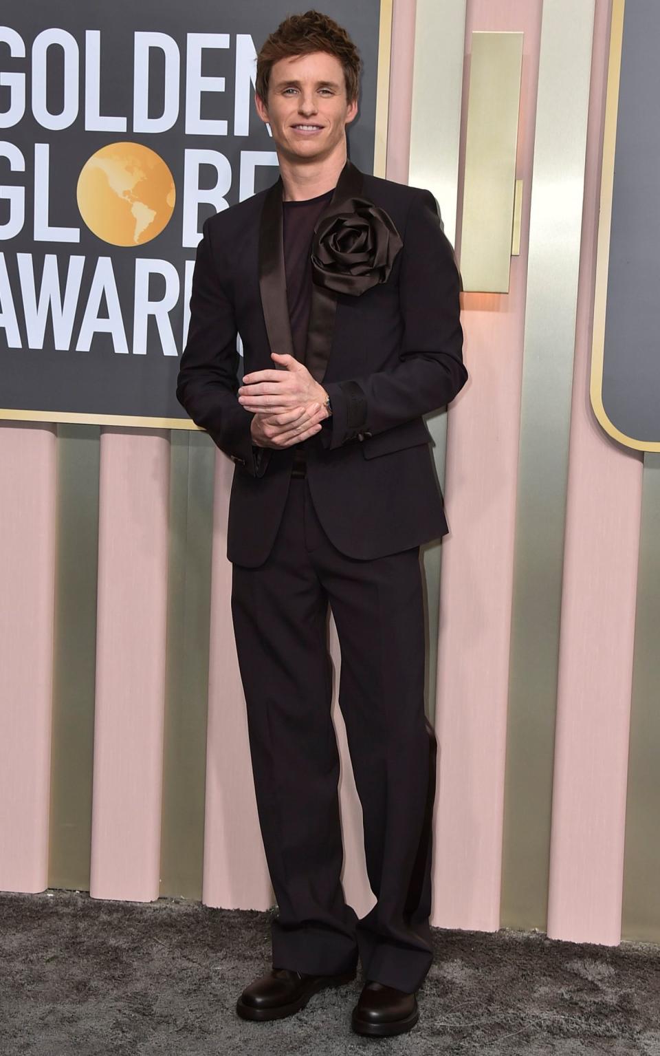 Eddie Redmayne in a chocolate Valentino suit with a corsage - Jordan Strauss