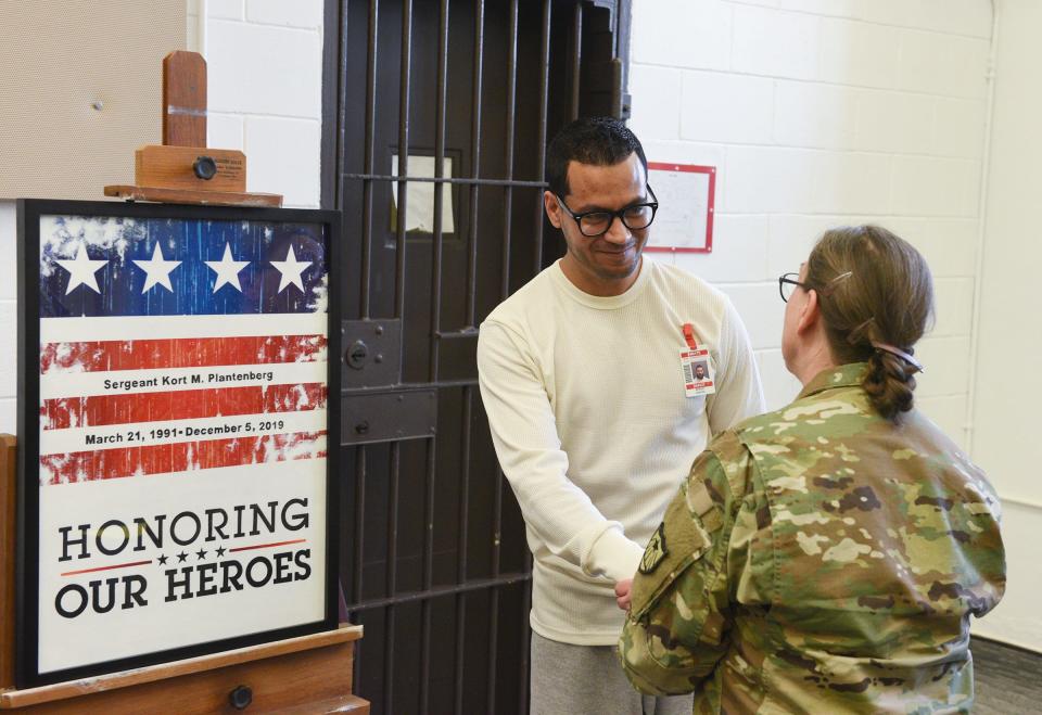 Sergio Zapata shakes hands with Diane Sandberg after his painting was unveiled Wednesday, March 4, 2020, at the St. Cloud prison.