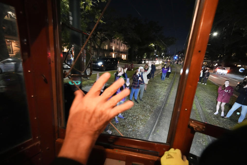 People on the street cheer as members of the Mardi Gras group The Phunny Phorty Phellows ride by reveling on a street car for their annual kick off of the Mardi Gras season on Twelfth Night in New Orleans, Friday, Jan. 6, 2023. (AP Photo/Gerald Herbert)