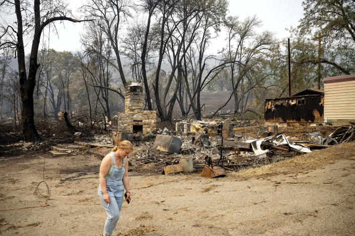 Sydney Corrales passes a lodge that burned during the McKinney Fire, Tuesday, Aug. 2, 2022, in Klamath National Forest, Calif. (AP Photo/Noah Berger)