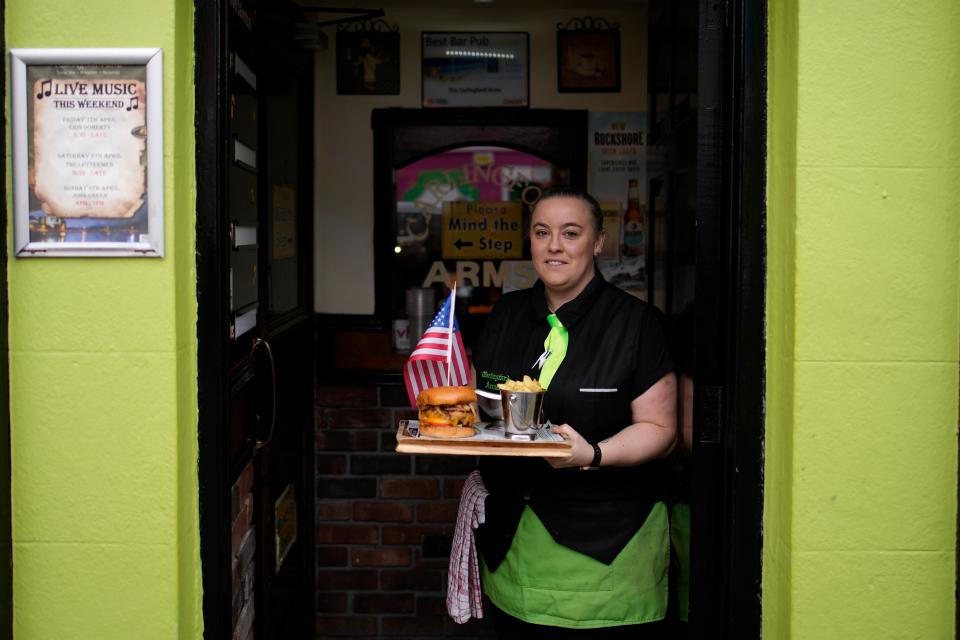 Sarah Delahunt holds out a tray with a burger and fries adorned with a United States flag (AP)