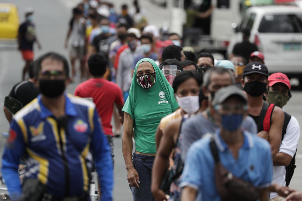 Jobless jeepney bus drivers line up to receive food donations as public transportation was again restricted during the lockdown in Quezon city, Philippines on Friday, Aug. 7, 2020. The capital and outlying provinces returned to another lockdown after medical groups warned that the country was waging a losing battle against the coronavirus amid an alarming surge in infections. (AP Photo/Aaron Favila)