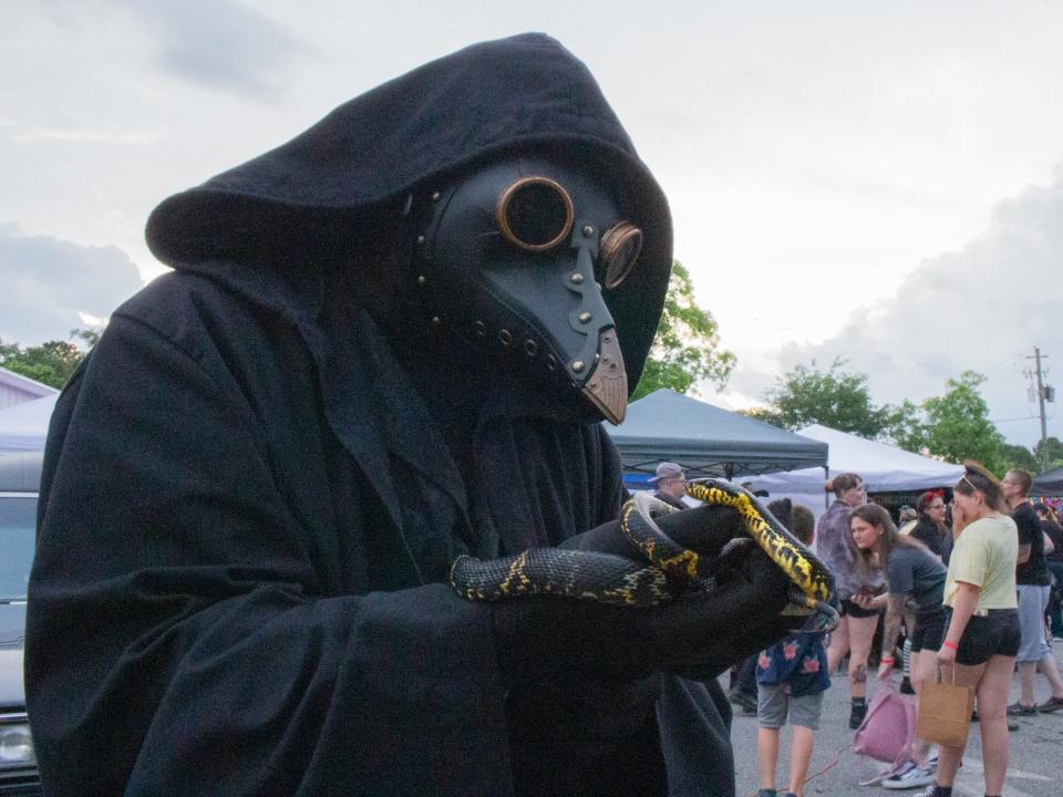 A costumed attendee interacts with a snake at HauntFest in Athens, Ga. on Saturday, May 13, 2023. The event returns for its second year on Friday, Apr. 6 and Saturday, Apr. 7, 2024.