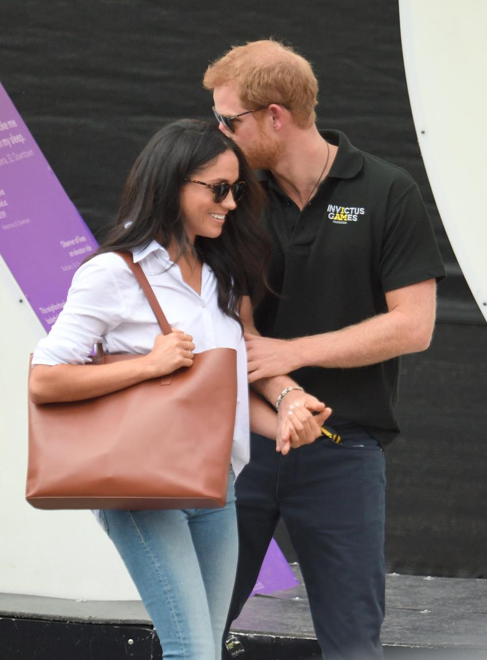 Prince Harry and Meghan Markle in 2017. Harry kisses Meghan on the forehead.