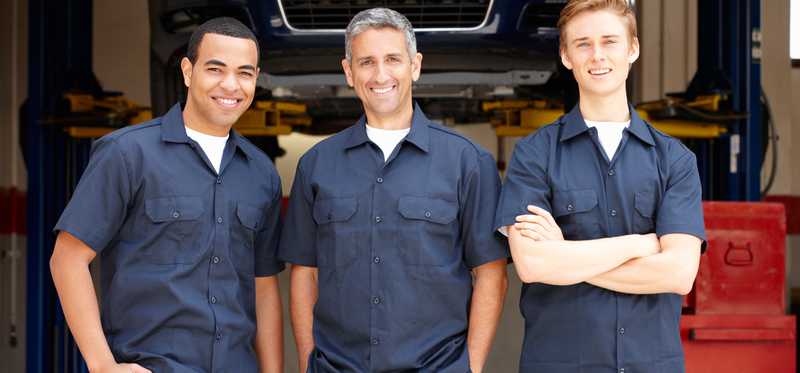Three male mechanics dress in uniforms.