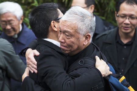 Occupy Central civil disobedience founders, Reverend Chu Yiu-ming (R) and Chan Kin-man, professor of sociology at Chinese University, embrace each other before surrendering to the police in Hong Kong December 3, 2014. REUTERS/Tyrone Siu