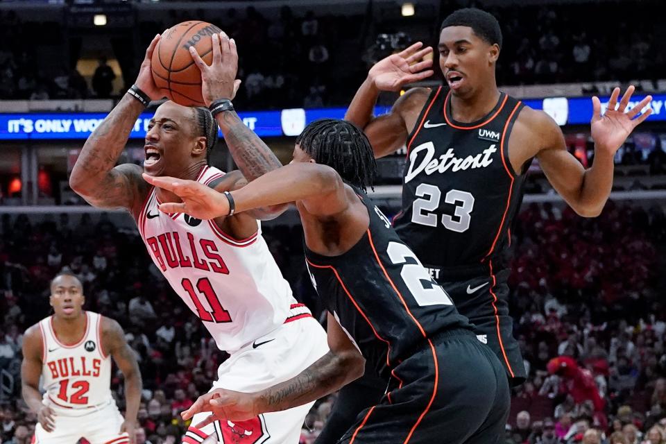 Chicago Bulls forward DeMar DeRozan, left, drives to the basket past Detroit Pistons guard Marcus Sasser and guard Jaden Ivey, right, during the first half at United Center in Chicago on Sunday, Nov. 12, 2023.