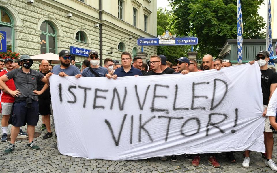 Hungary's supporters are seen at Wienerplatz as they hold a banner reading "God is with you Viktor", - AFP